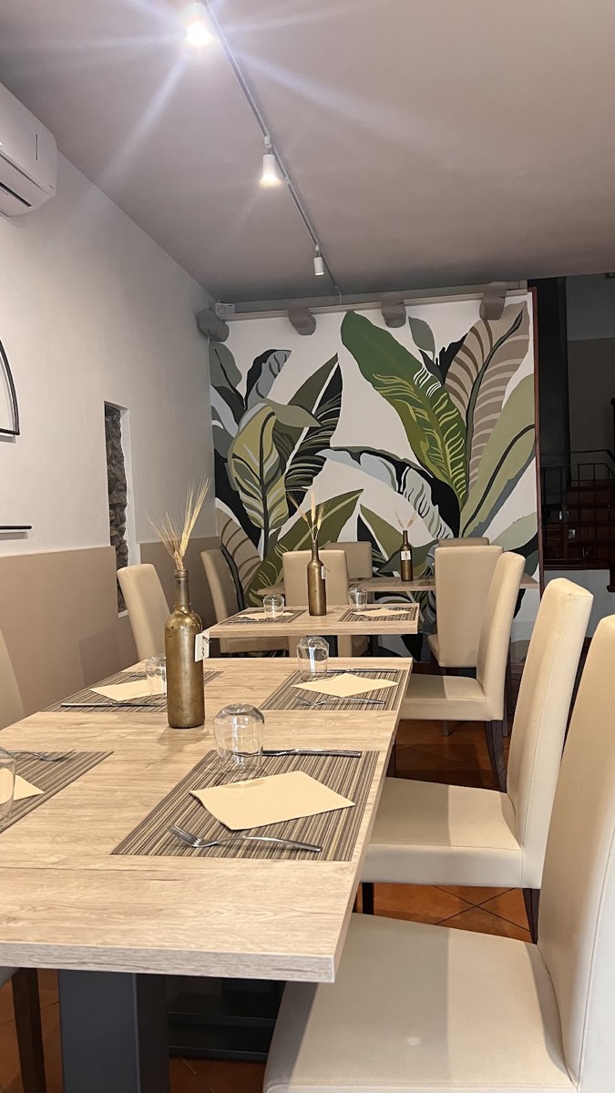 La sala interna con murale di foglie e sedute chiare